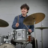 Jacobo Vega-Albela smiling behind his drum kit